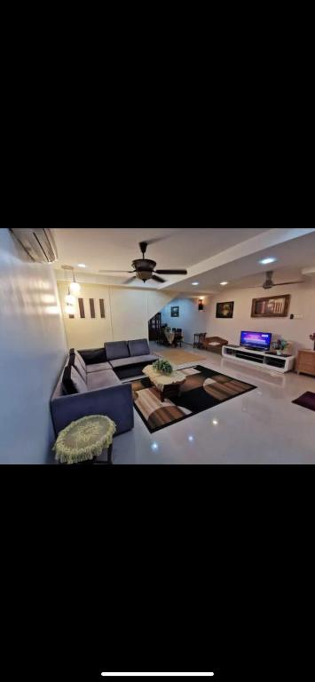salon z kanapami i wentylatorem sufitowym w obiekcie A Spacious 3BR 2storey House Taman Kosas Ampang w mieście Ampang