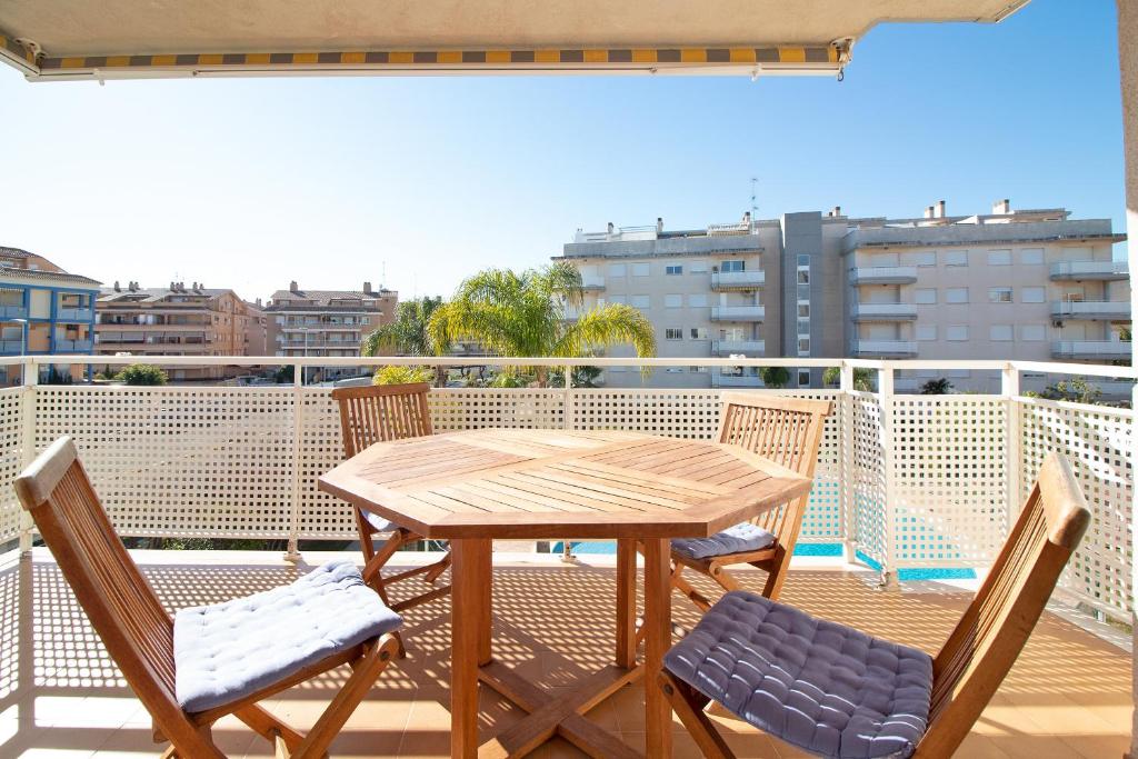 uma mesa de madeira e cadeiras numa varanda em Global Properties, Apartamento con terraza en Canet de Berenguer em Canet d'En Berenguer