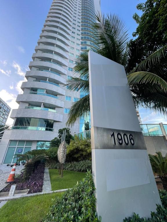 a sign in front of a tall building at 2703 Flat Beira Mar Av Boa Viagem com Cozinha in Recife