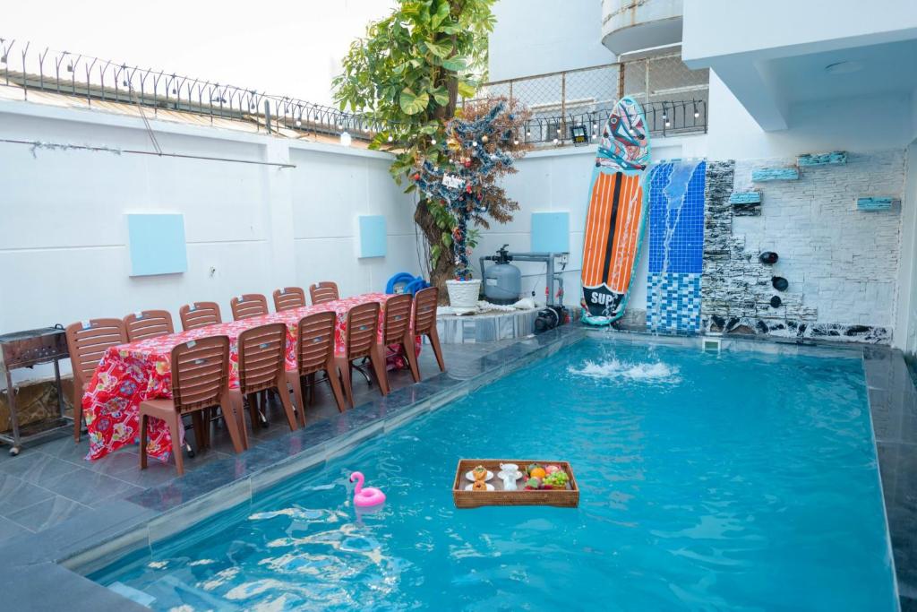 a swimming pool with chairs and a table and a toy duck in the water at S1 VILLA - SunHill Villa in Vung Tau