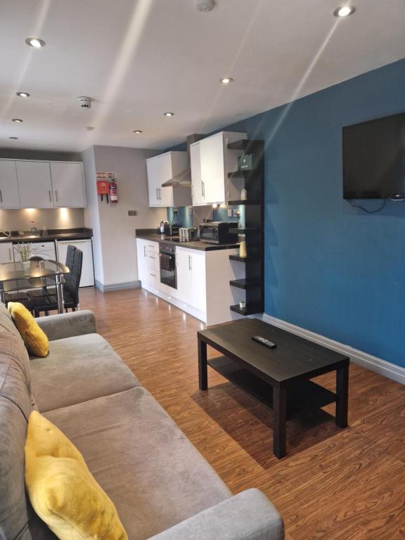 sala de estar con sofá, mesa y cocina en Well located Northern Quarter Apartment sleeps Upto 6, en Mánchester