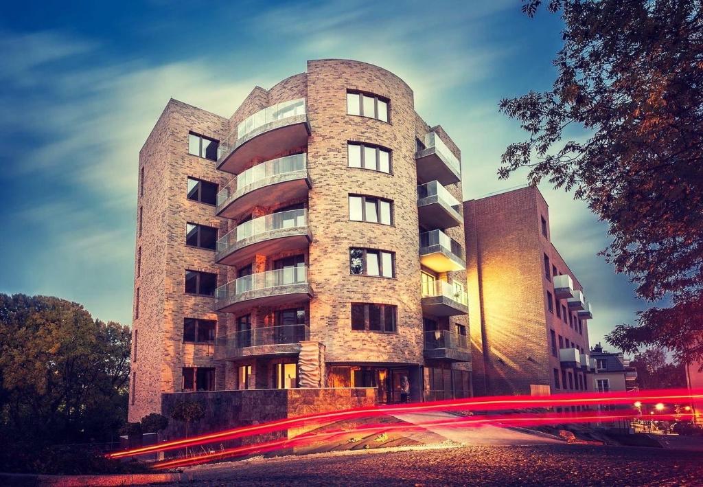 a tall brick building with a street in front of it at Apartament Villa Łyna Park in Olsztyn