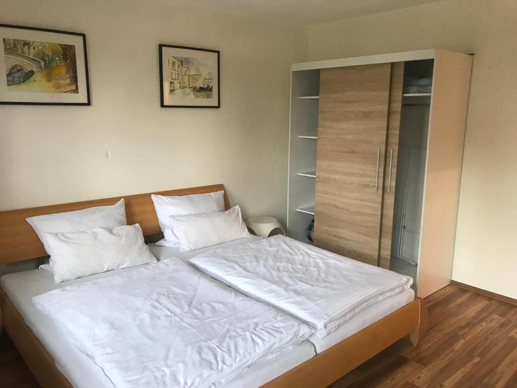 Una cama con sábanas blancas y almohadas en un dormitorio en Ferienwohnung Seebruck am Chiemsee en Seebruck