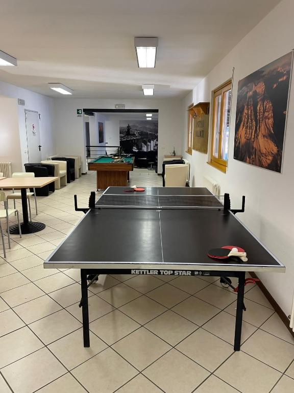 a ping pong table in the middle of a room at Lunga Via Delle Dolomiti in Calalzo