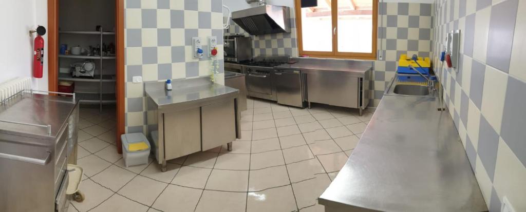 a kitchen with stainless steel appliances and a tiled floor at Lunga Via Delle Dolomiti in Calalzo