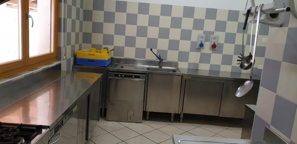 a small kitchen with a sink and a stove at Lunga Via Delle Dolomiti in Calalzo