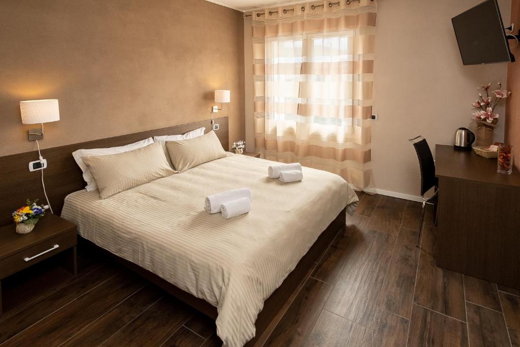 ein Schlafzimmer mit einem großen Bett mit zwei Handtüchern darauf in der Unterkunft The White Building - [ROOMS] in Costermano sul Garda