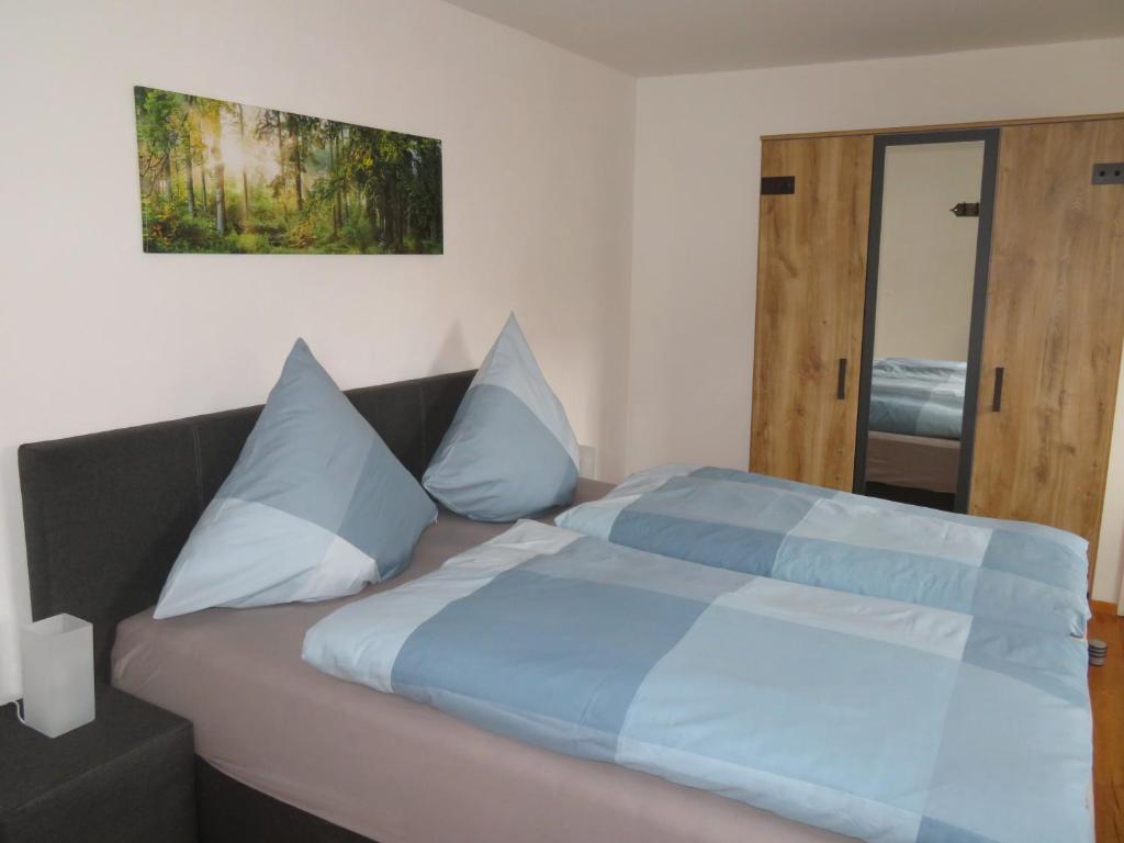 una camera da letto con un letto con cuscini blu e bianchi di Doppelzimmer Dresden - Wilschdorf Monteurunterkunft a Dresda