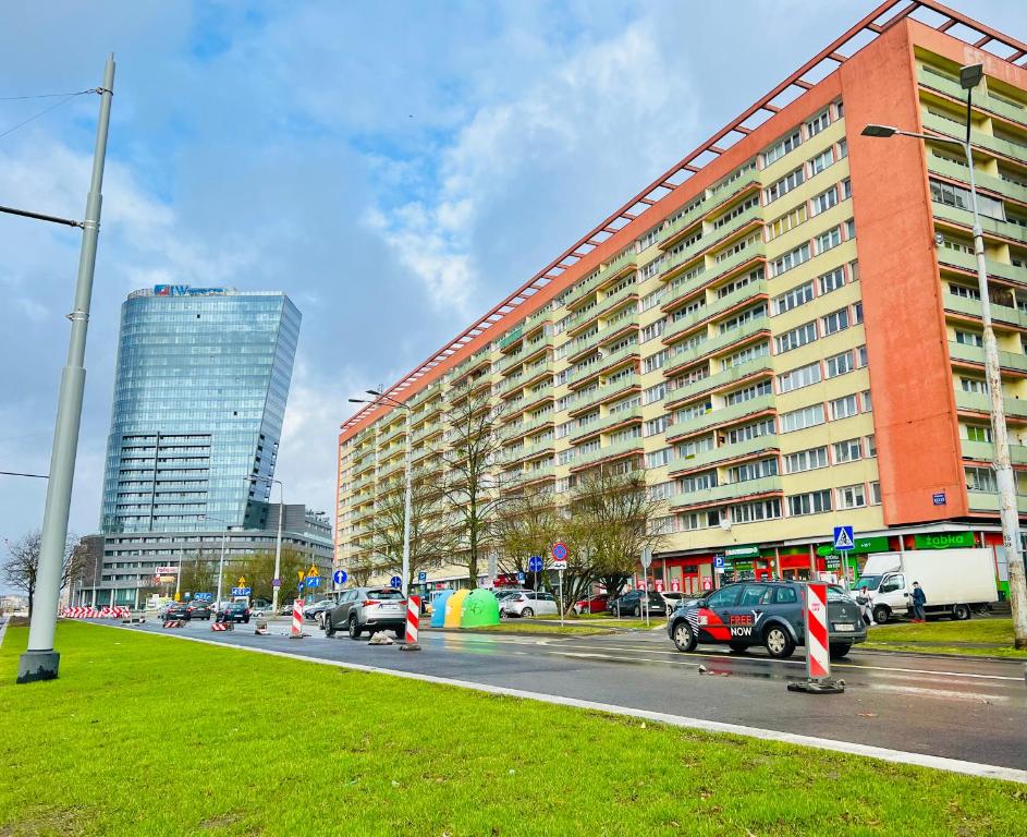 un gran edificio con coches aparcados en una calle en Apartament Centrum Wyzwolenia, en Szczecin
