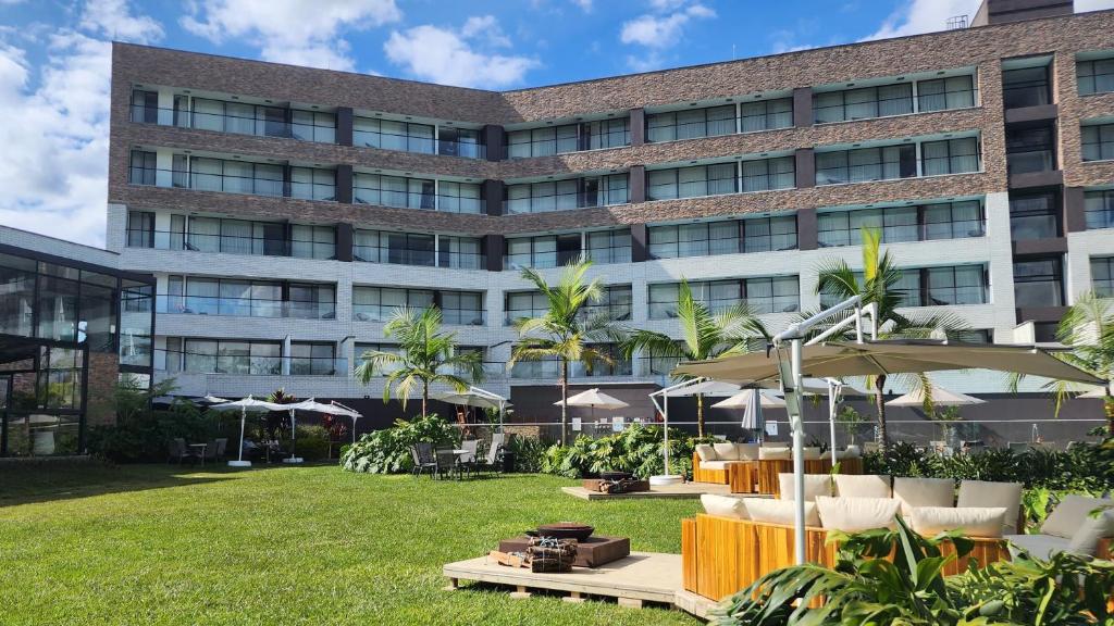 einen Außenblick auf ein Gebäude mit Stühlen und Sonnenschirmen in der Unterkunft Hotel Lagoon in Rionegro