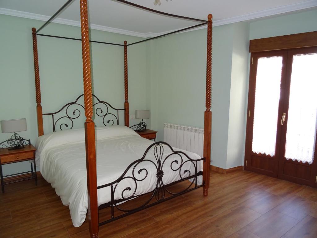 - une chambre avec un lit à baldaquin et des draps blancs dans l'établissement El soportal, à Barbadillo del Pez