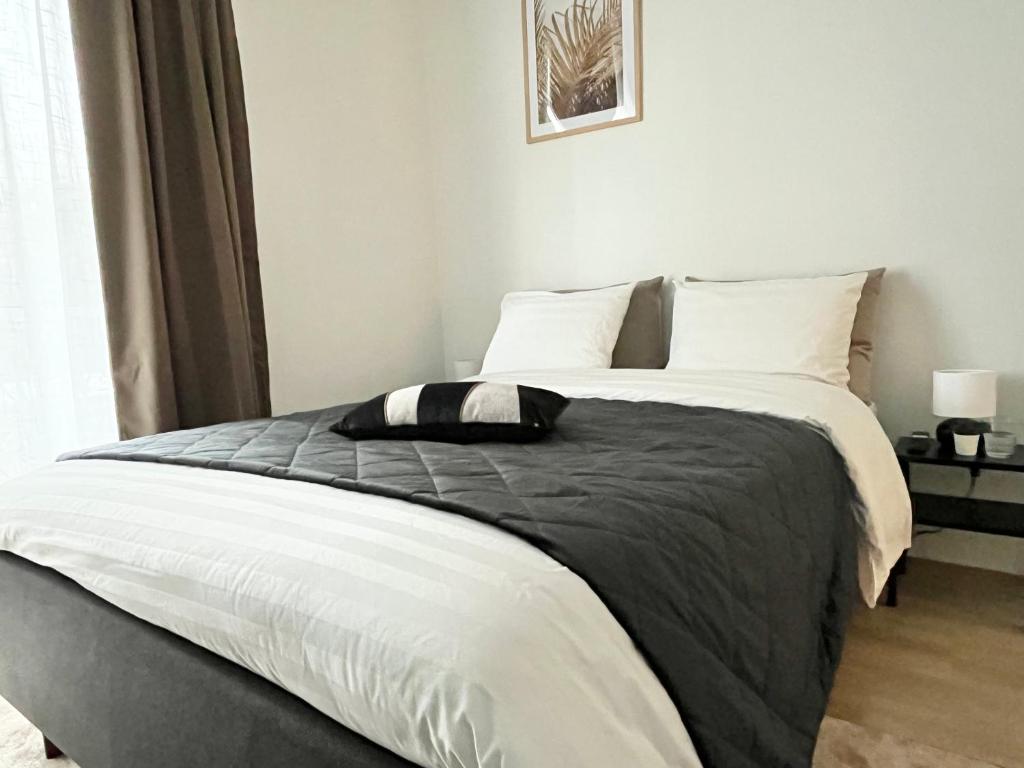 a bed with a black and white comforter in a bedroom at Tammer Huoneistot - City Suite 4 - Perfect Location & Great Amenities in Tampere