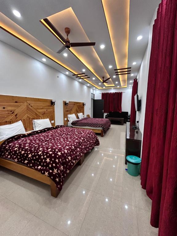 a bedroom with two beds and red curtains at HOTEL HIMALAYAN FOXHOLE in Chakrāta