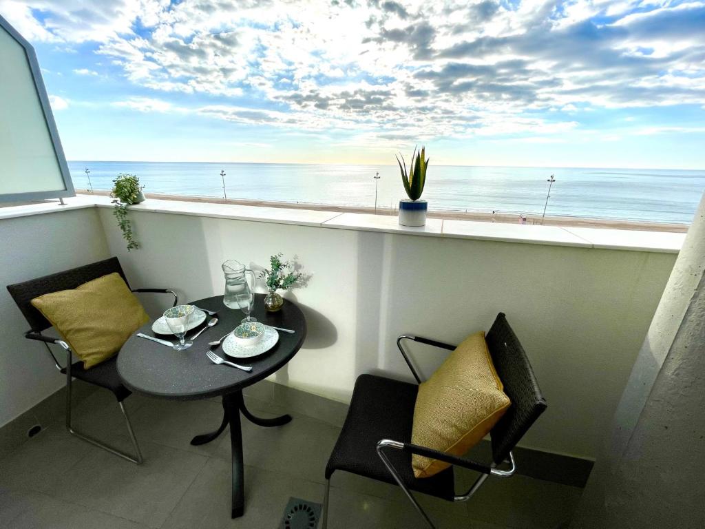 a table and chairs in a balcony with a view of the ocean at GATU Villa Camarote con vistas al mar in Cádiz