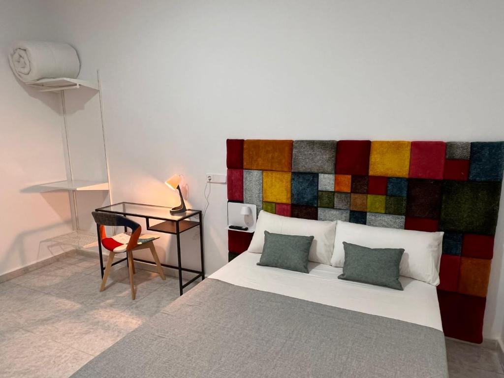 een slaapkamer met een groot bed met een kleurrijk hoofdeinde bij CH Barco in Madrid