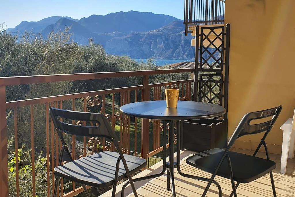 een tafel en stoelen op een balkon met uitzicht bij Andy Apt zona tranquilla vicino centro e spiaggia in Malcesine