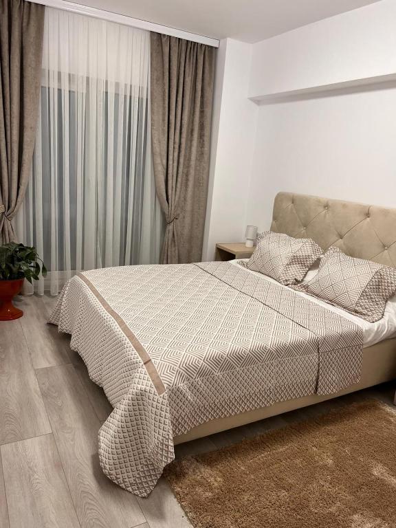 1 dormitorio con 1 cama con manta a cuadros en Apartament 2 camere Proximitate Aeroport, en Iaşi