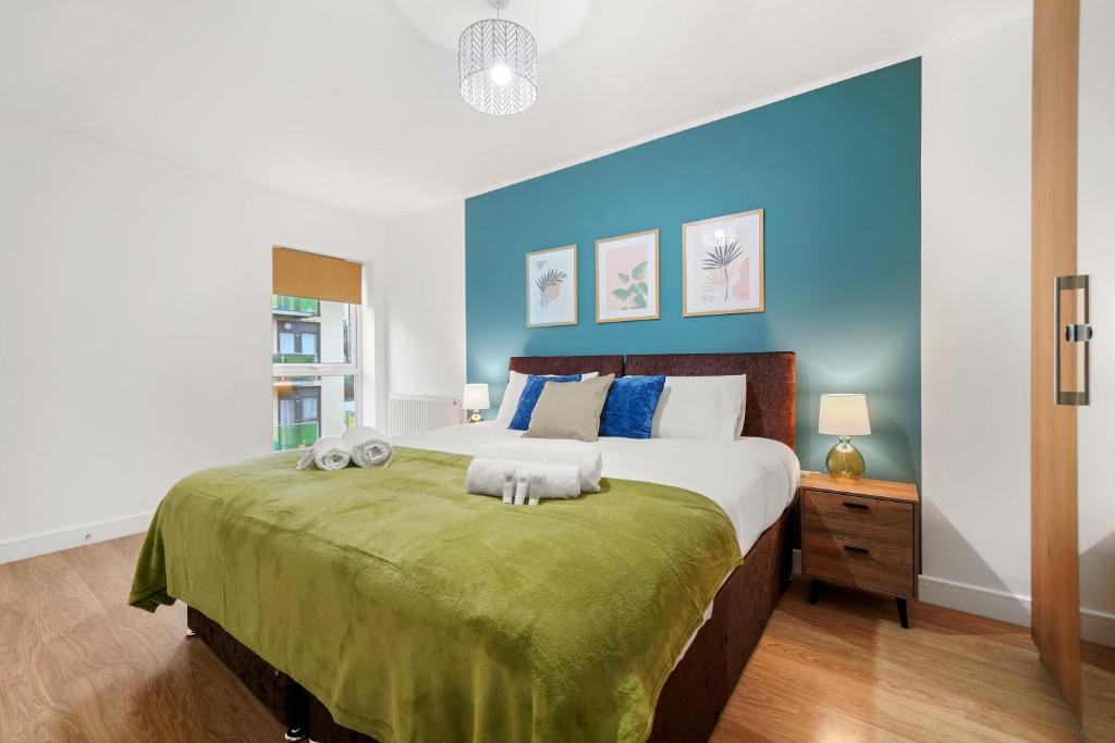 a bedroom with a large bed with a blue wall at East London Townhouse sleeps 7 with 1 parking space in Goodmayes