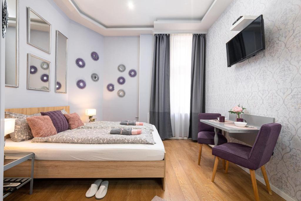 1 dormitorio con cama, mesa y TV en Synagogue Apartments, en Budapest