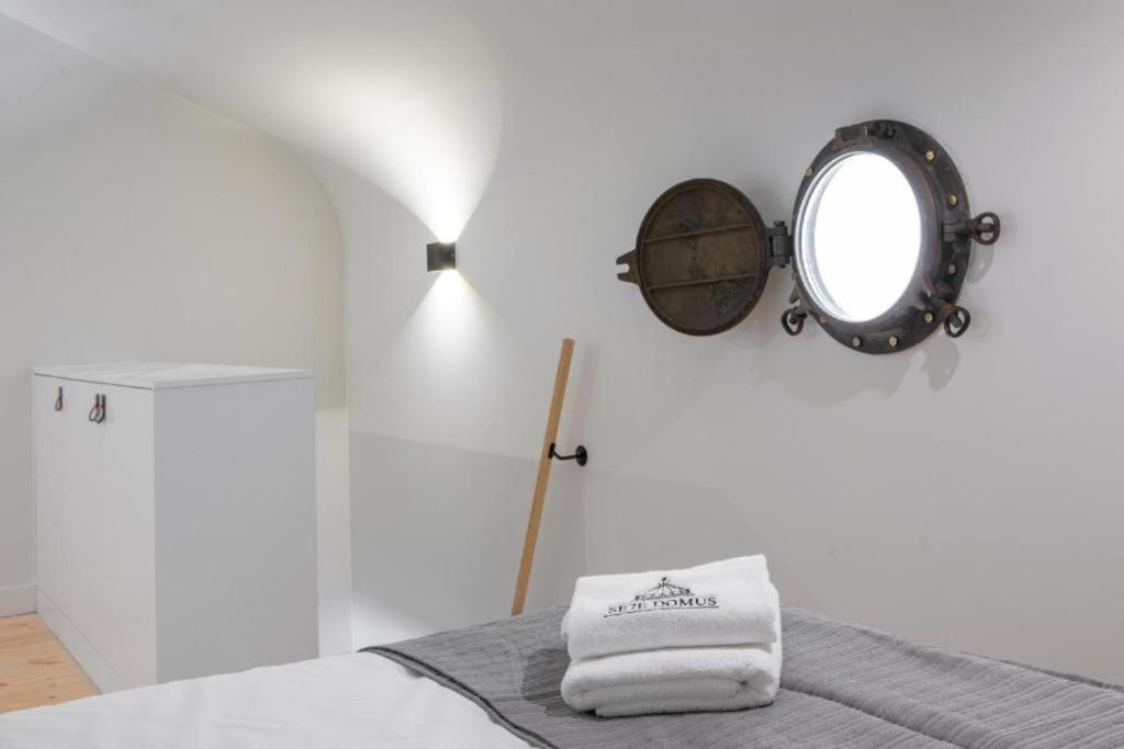 Habitación blanca con espejo y cama en MyStay Porto Bolhão - Pool & Garden, en Oporto
