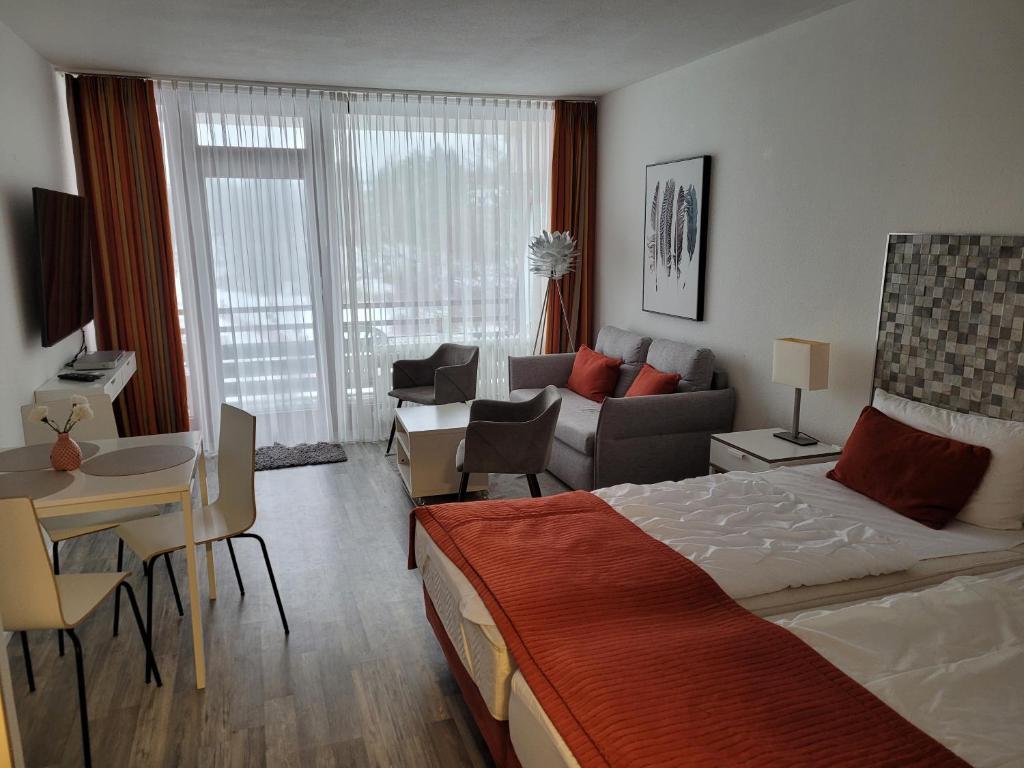 - une chambre avec un lit et un salon dans l'établissement Apartment mit Seeblick Vier Jahreszeiten, à Hahnenklee