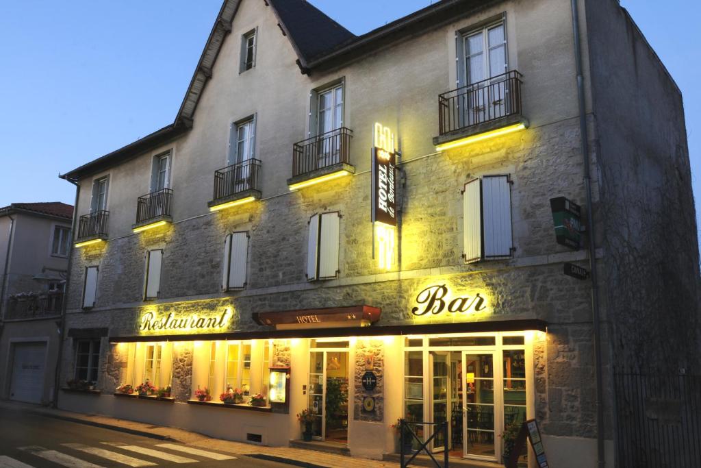 a building with a bar sign on the side of it at Hotel de Bordeaux in Gramat