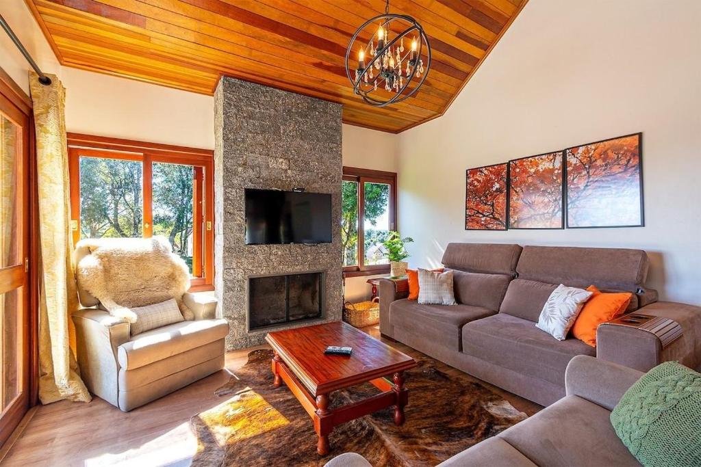 a living room with a couch and a fireplace at Rosa Casa Vivendas da Colina in Canela