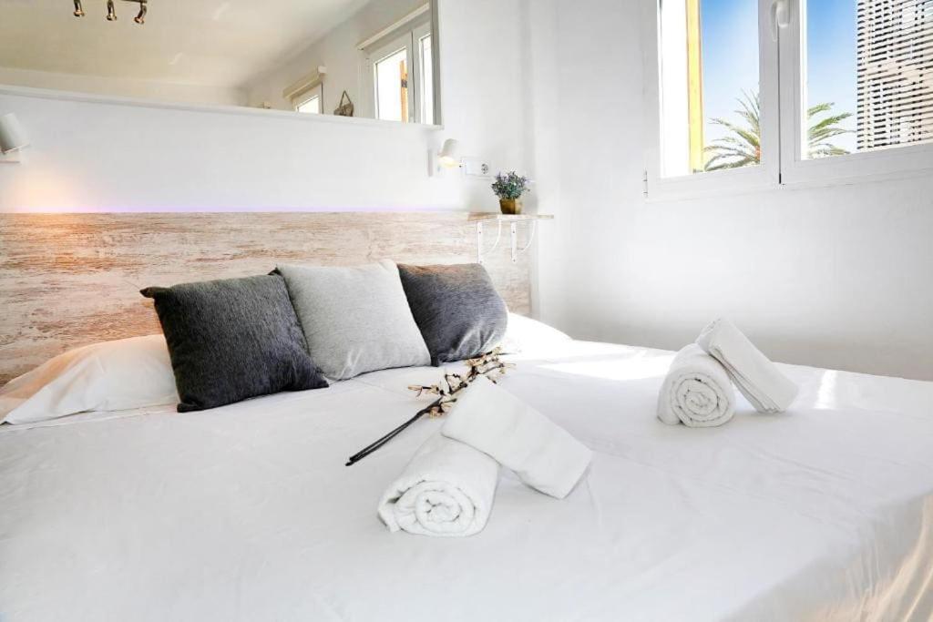 - un lit blanc avec des serviettes et des oreillers dans l'établissement Wind Rose study, à Jávea