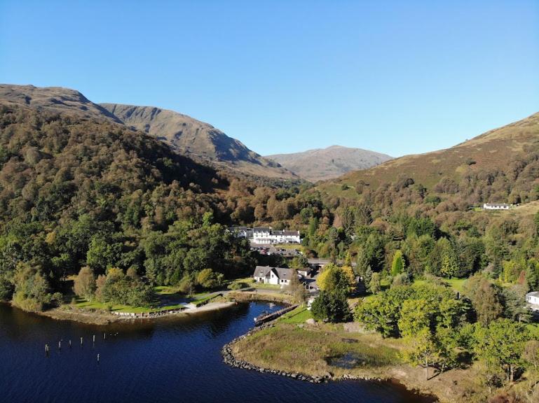 an island in the middle of a lake in the mountains at The Inn on Loch Lomond in Luss