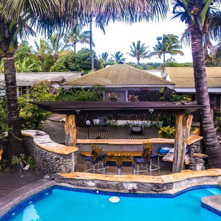 a resort with a swimming pool and a house at CHEZ MARIA GORETTI HOTEL in Hanga Roa