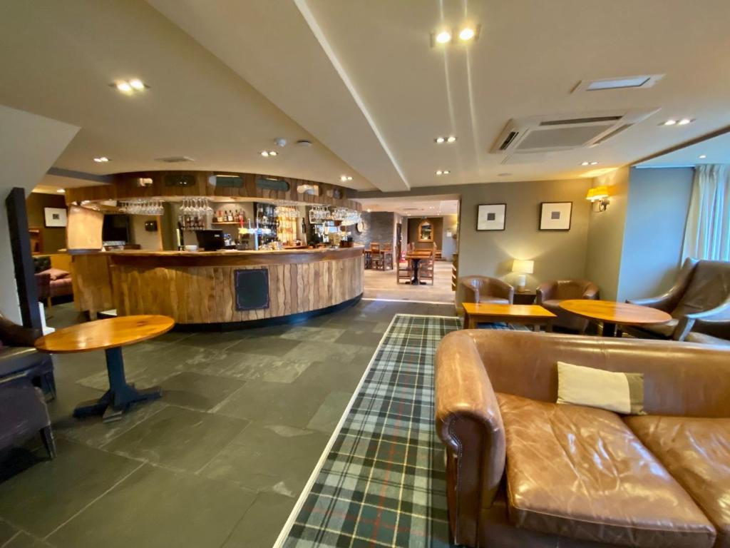 a lobby with a couch and a bar at The Inn on Loch Lomond in Luss