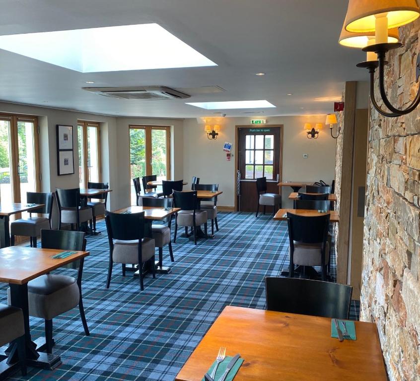 a dining room with tables and chairs and tablesktop at The Inn on Loch Lomond in Luss