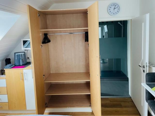 a room with a closet with a clock on the wall at Haus Dragl DZ EZ in Friedberg