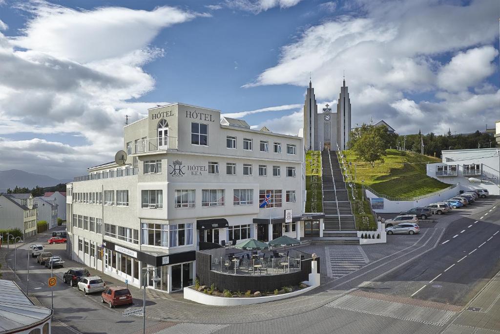a white building on a city street with a church at Hotel Kea by Keahotels in Akureyri