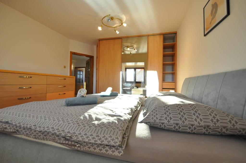 ein Schlafzimmer mit einem großen Bett und einer Kommode in der Unterkunft Rodinný dom "Ako doma" in Veľký Slavkov