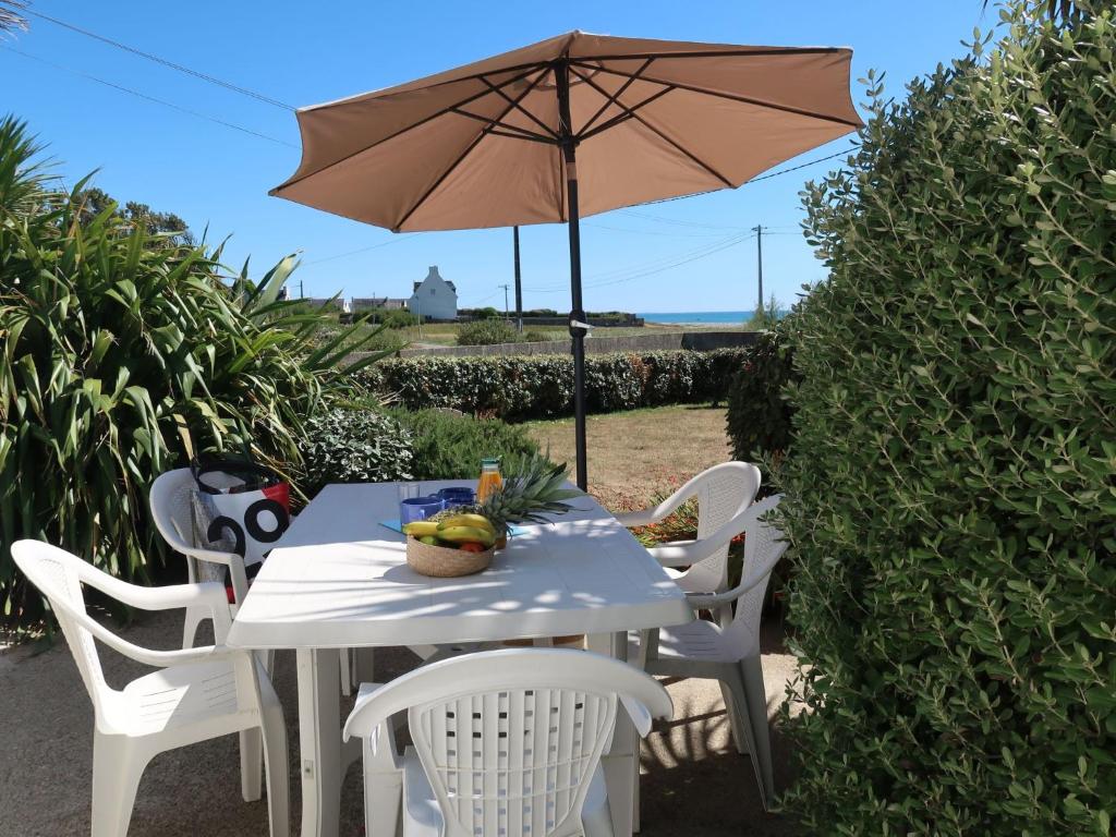PlozévetにあるHoliday Home Partie de pêche - PZV102 by Interhomeの白いテーブル(傘、白い椅子付)