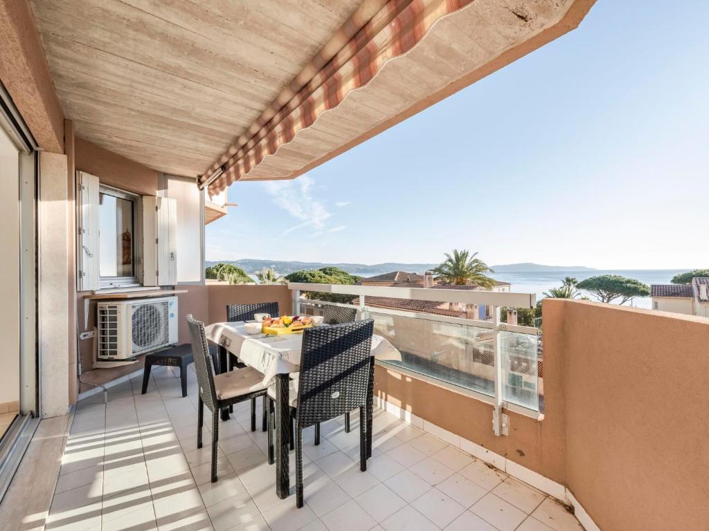 patio ze stołem i krzesłami na balkonie w obiekcie Apartment Les Jardins del Mar-2 by Interhome w mieście Cavalaire-sur-Mer