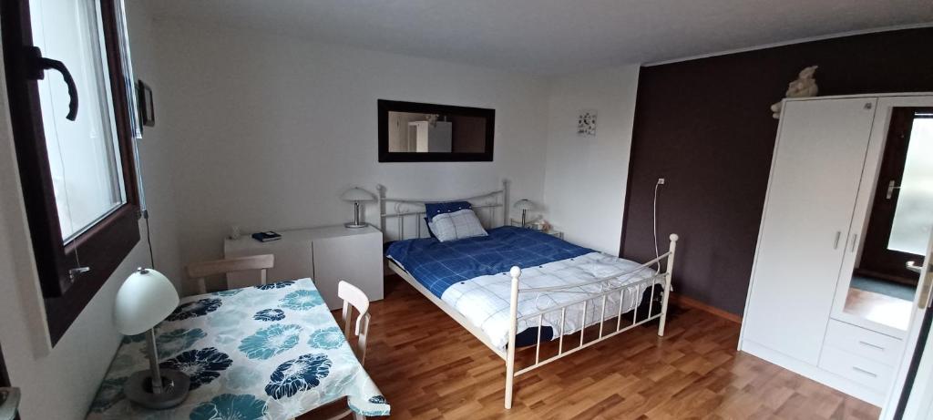 Dormitorio pequeño con cama y mesa en BnB chez Fanfan, en Morges