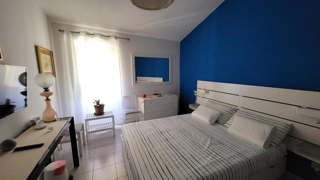 um quarto azul com uma cama e uma janela em Itiseasy Cuglieri 1 e 2 Private Apartments em Cuglieri