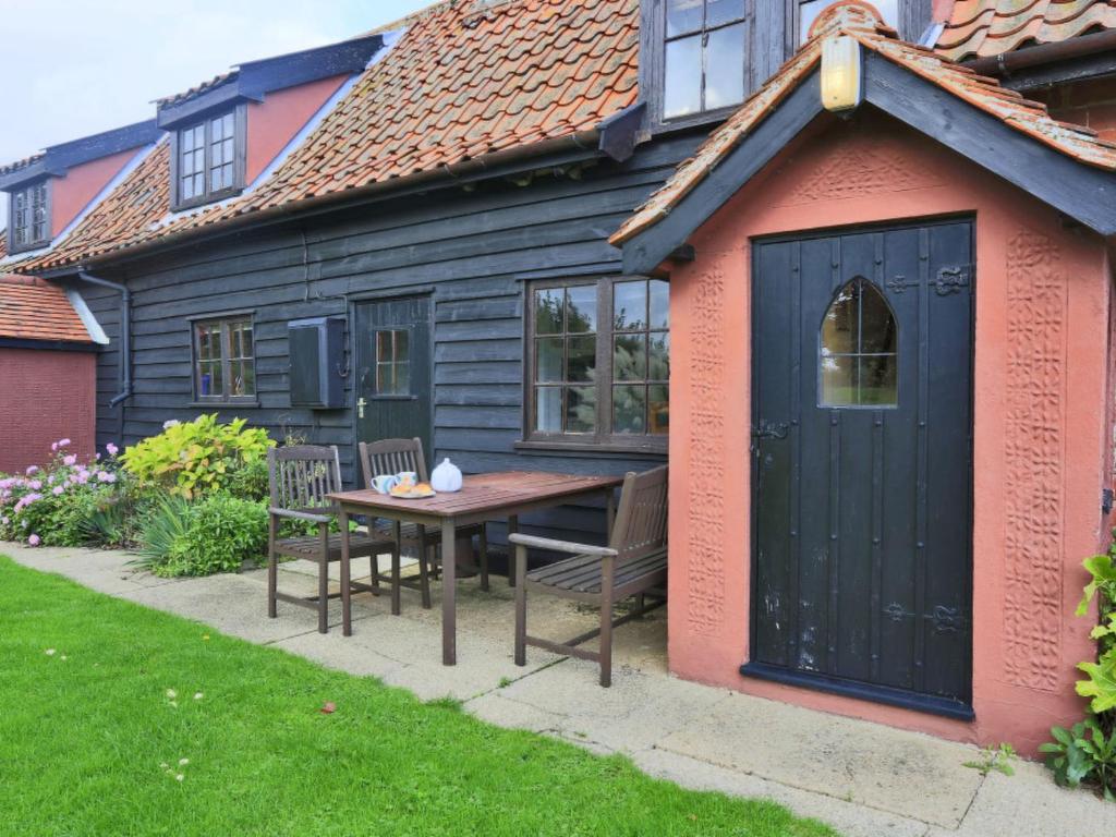 a shed with a table and chairs in front of a house at Holiday Home Eelsfoot by Interhome in Hemley