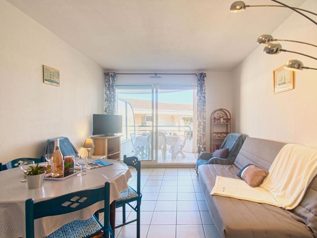 a living room with a couch and a table at Apartment Le Cesarée-2 by Interhome in Fréjus