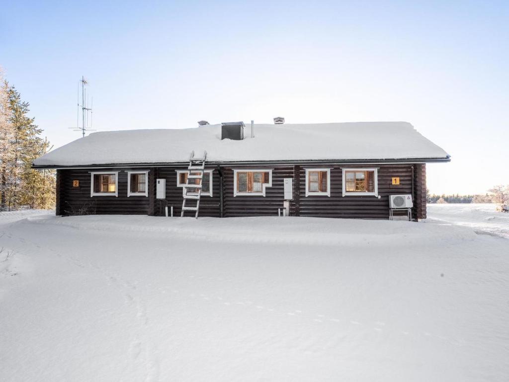 a house with a snow covered driveway in front of it at Holiday Home Ruka-kitkan lomamajat-tilhi by Interhome in Säkkilänvaara