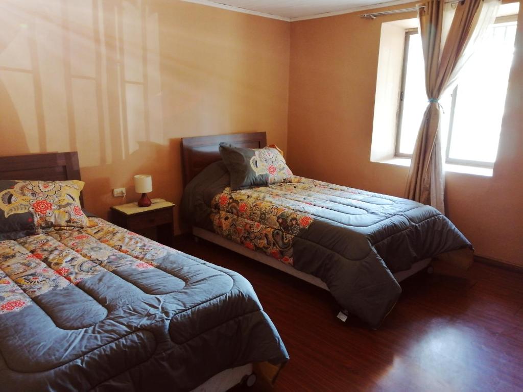 a bedroom with two beds and a window at Hostel Casa Descanso Natural in Panimávida