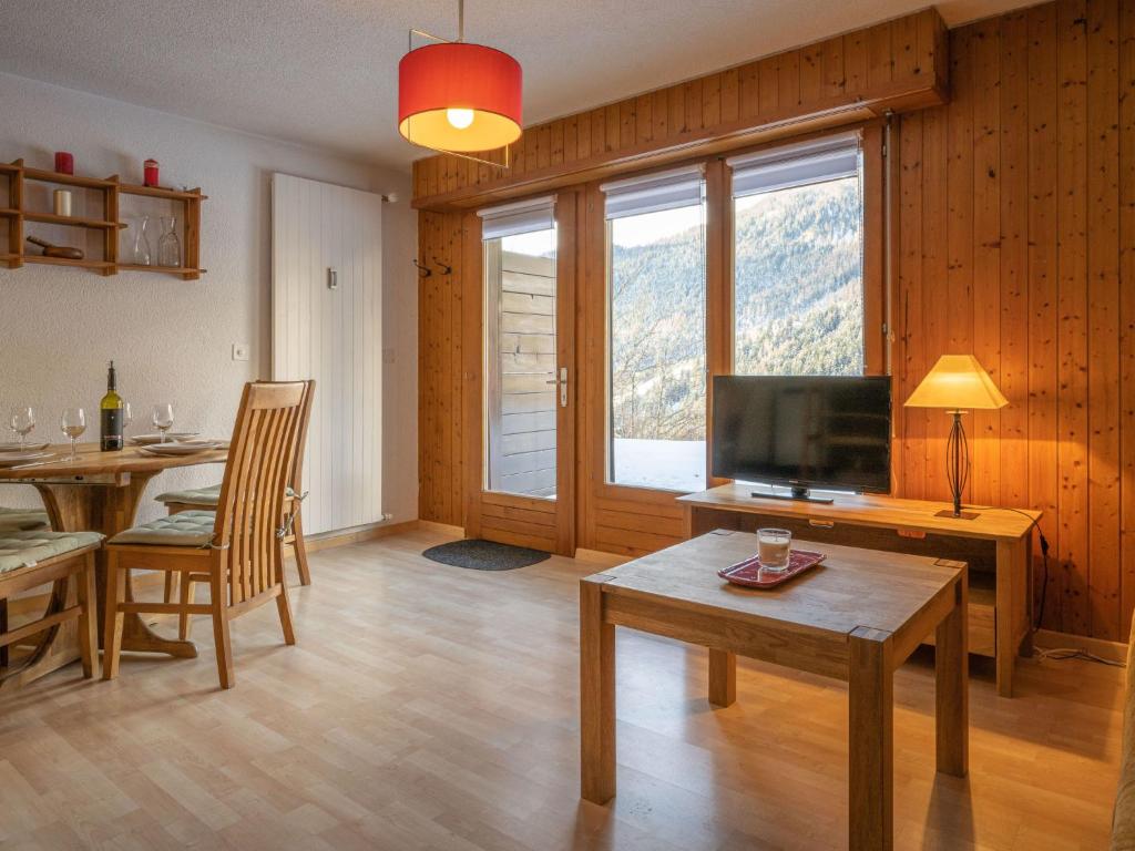 a living room with a table and a television at Apartment Jorasse A 1 by Interhome in Ovronnaz