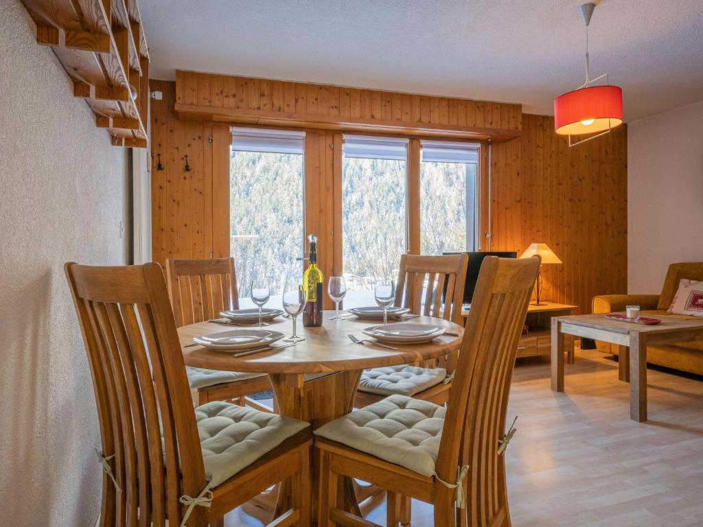 a dining room with a wooden table and chairs at Apartment Jorasse A 1 by Interhome in Ovronnaz