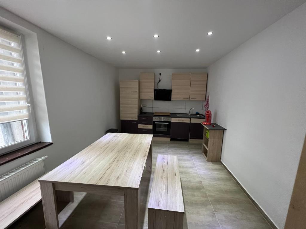 a kitchen with a wooden table in a room at Ferien- und Monteurunterkunft Alsdorf in Alsdorf