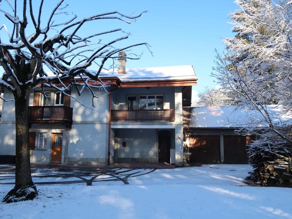 a house in the snow with a tree at Apartment Le Verger by Interhome in Bex