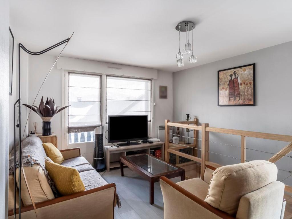 a living room with a couch and a tv at Apartment L'Orée du Parc by Interhome in Saint-Gervais-les-Bains