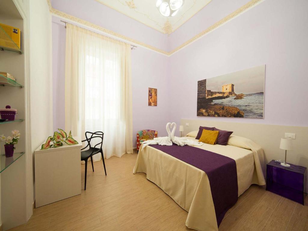 una camera da letto con un letto e un dipinto sul muro di Belle Epoque B&B a Trapani