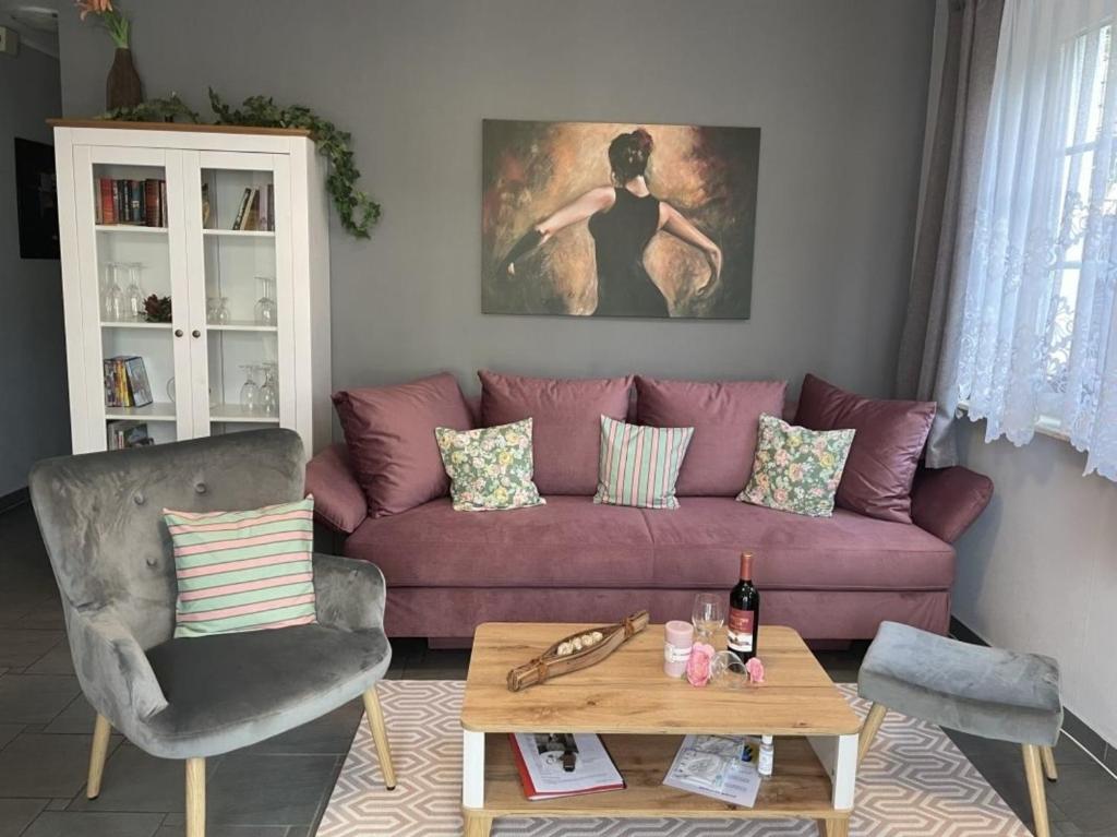 ein Wohnzimmer mit einem lila Sofa und einem Tisch in der Unterkunft Ferienwohnung LePetit in Steina